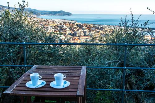 a wooden table with two coffee cups on top of it at Le terrazze sul mare in Chiavari