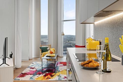 a kitchen with a table with a plate of food and wine bottles at ShyTower in London