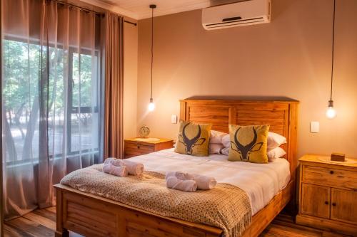 ein Schlafzimmer mit einem Bett mit zwei Teddybären darauf in der Unterkunft The Porcupine Porch in Marloth Park