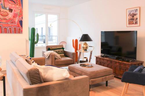 un salon avec des canapés et une télévision à écran plat dans l'établissement Spacious 3 Bedrooms with Terrace Saint Ouen, à Saint-Ouen