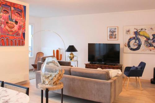 un salon avec un canapé et une télévision à écran plat dans l'établissement Spacious 3 Bedrooms with Terrace Saint Ouen, à Saint-Ouen