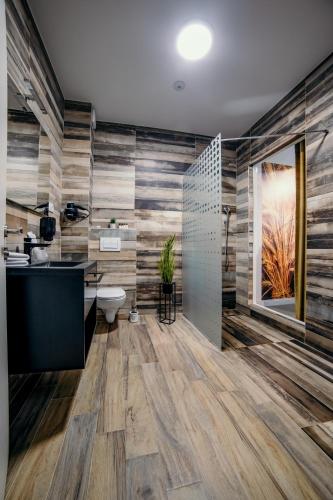 a bathroom with a toilet and a sink at Hotel Nordic Twins & Wellness in Rădăuţi