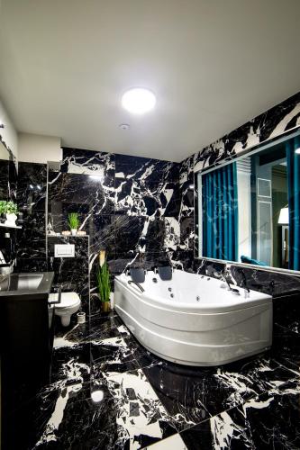a black and white bathroom with a tub and sinks at Hotel Nordic Twins & Wellness in Rădăuţi