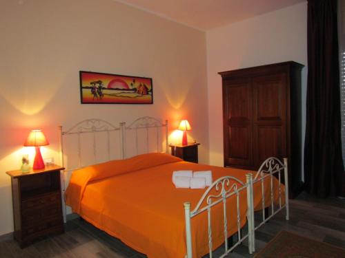 ガリポリにあるB&B Eco Dal Mareのベッドルーム1室(オレンジ色のベッドカバー、ランプ2つ付)
