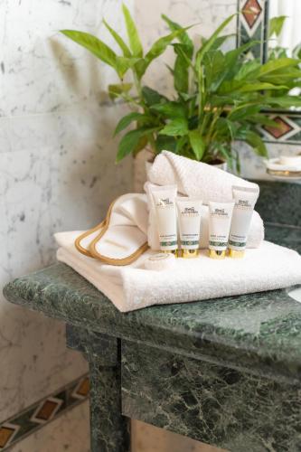 a pile of towels on a table with a plant at Hotel Villa La Bollina in Serravalle Scrivia