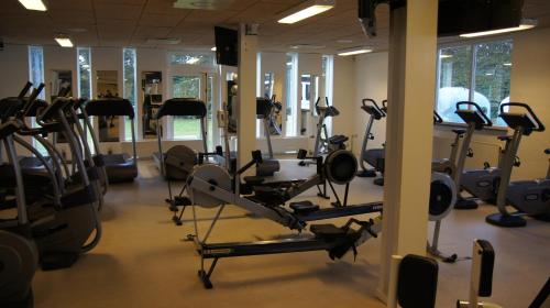 a gym with several treadmills and elliptical machines at Helle Aktivitetshotel in Årre