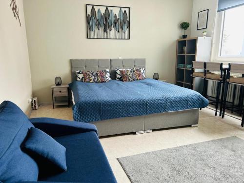 a bedroom with a blue bed and a blue couch at LENASTAY I Modernes Apartment-Studio near Uni in Kaiserslautern