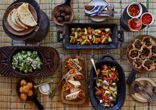a table topped with plates of food and bowls of food at Geiger's Camp in Timbavati Game Reserve by NEWMARK in Timbavati Game Reserve