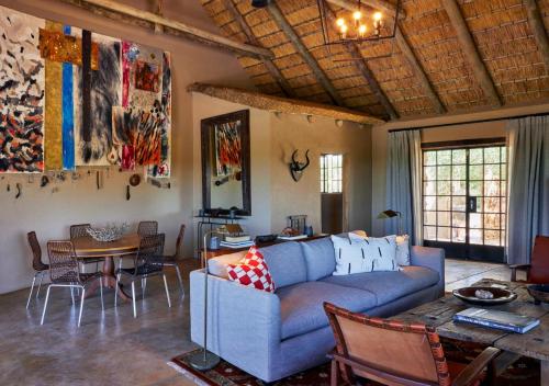 a living room with a blue couch and a table at Geiger's Camp in Timbavati Game Reserve by NEWMARK in Timbavati Game Reserve