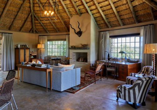 a living room with a couch and a desk at Geiger's Camp in Timbavati Game Reserve by NEWMARK in Timbavati Game Reserve