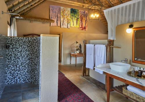 a bathroom with a shower and a sink in a room at Geiger's Camp in Timbavati Game Reserve by NEWMARK in Timbavati Game Reserve