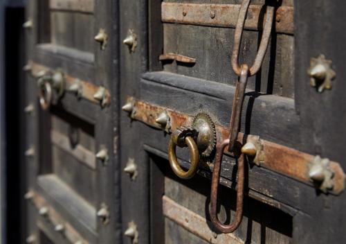 a group of old wooden doors with rusty handles at Geiger's Camp in Timbavati Game Reserve by NEWMARK in Timbavati Game Reserve