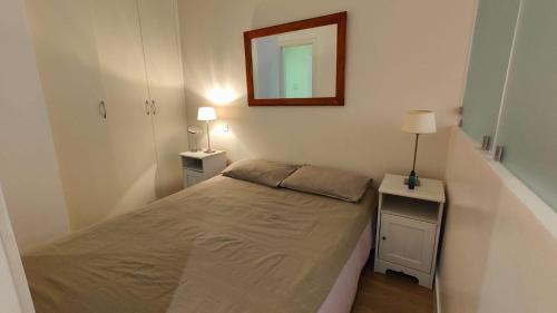 une petite chambre avec un lit et un miroir dans l'établissement Beach Proximity in Historic Nice, Your Perfect 2 Room Rental, à Nice