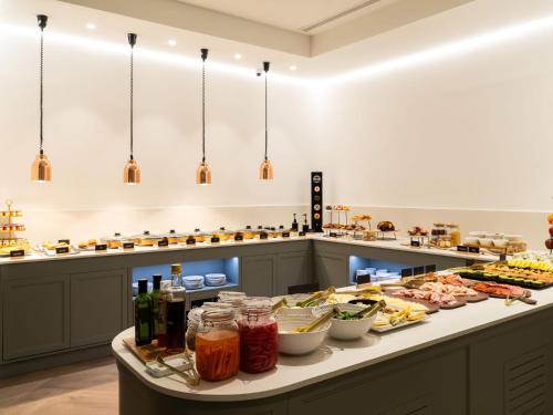 a buffet line with food and drinks on it at Hotel Well and Come Málaga in Málaga