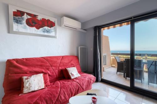 un canapé rouge dans un salon avec vue dans l'établissement T2 sea view in Saint-Clair - Rated 3, au Lavandou
