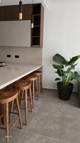 a kitchen with a table with stools and a potted plant at Dahan Sirena lighthouse Luxury Apartment in Paphos