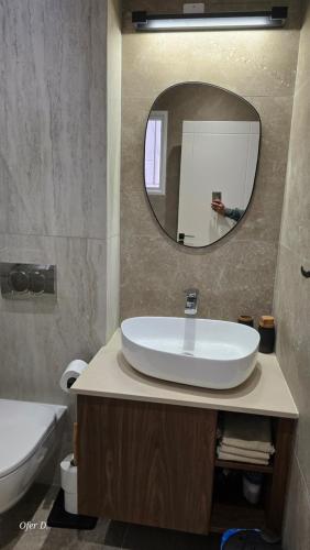 a bathroom with a sink and a mirror at Dahan Sirena lighthouse Luxury Apartment in Paphos