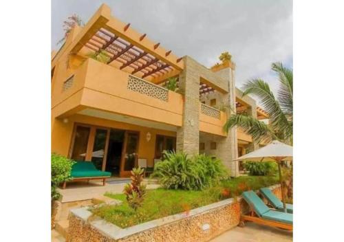 a villa with a pool and a resort at Villa Mandhari - Diani Beach in Diani Beach