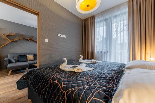 タトランスカ・ロムニツァにあるZlatý Apartmán, Granit 106のベッドルーム1室(白鳥2羽のベッド1台付)