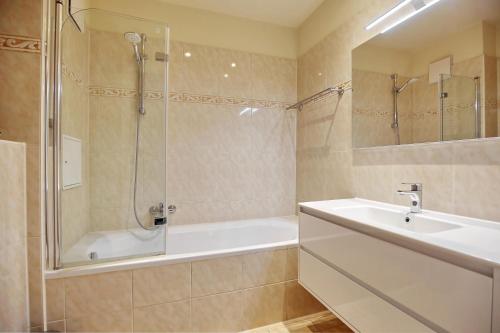 a bathroom with a tub and a sink and a shower at Villa Seepferdchen Wohnung 10 in Kühlungsborn