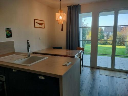 une cuisine avec un évier et une grande fenêtre dans l'établissement Ref 028 Bel appartement RDC pour 4 personnes avec terrasse et piscine l'été, à Arzon