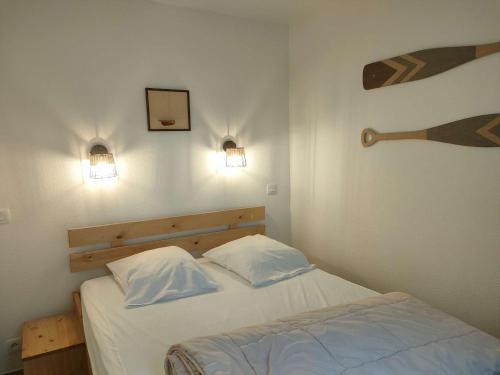 une chambre avec un lit avec deux oreillers blancs dans l'établissement Ref 028 Bel appartement RDC pour 4 personnes avec terrasse et piscine l'été, à Arzon