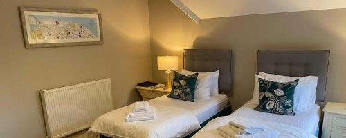 two beds in a small room with two towels at Little Massingham Manor in Little Massingham