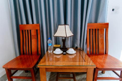 宁平Tam Coc Minh Quan Bungalow & Homestay的一张桌子、两把椅子、一盏灯和一瓶水