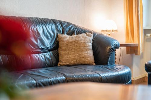 a brown pillow sitting on a leather couch at Kolbatzer Mühle in Lychen
