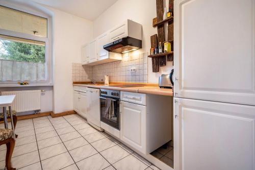 a kitchen with white cabinets and a white refrigerator at Kolbatzer Mühle in Lychen