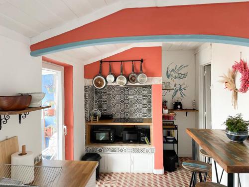 a kitchen with an orange and white wall at Casa Pássaro in Vila Franca de Xira