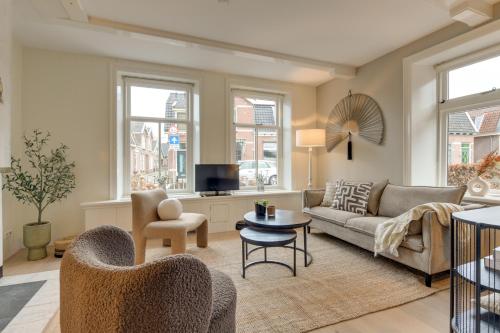 a living room with a couch and a tv at Boutique Hoeve de Berg in Uitgeest