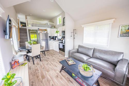 a living room with a couch and a table at Rainforest Tiny Home Retreat Farmhouse 18 in Forks