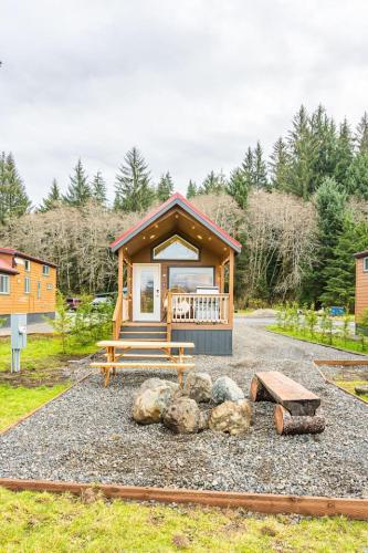 a small cabin with a porch and some rocks at Rainforest Tiny Home Retreat 27 in Forks