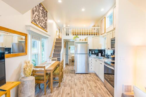 a kitchen with white cabinets and a table and a dining room at Rainforest Tiny Home Retreat 27 in Forks