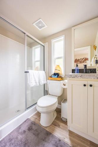 Un baño blanco con inodoro y ducha. en Rainforest Tiny Home Retreat 19, en Forks
