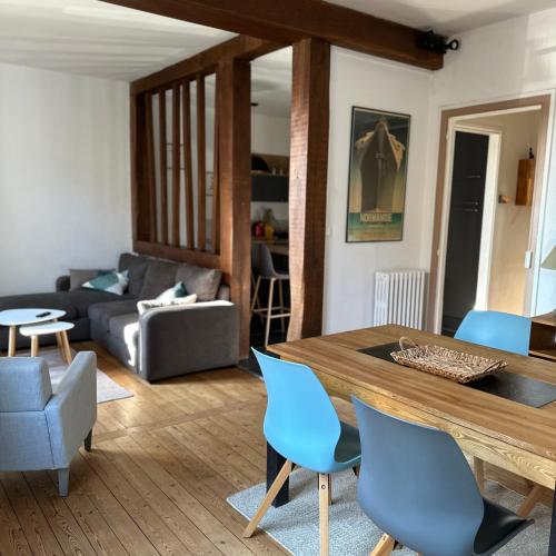 - un salon avec une table en bois et des chaises bleues dans l'établissement Séduisant T2 Plage du Havre, au Havre