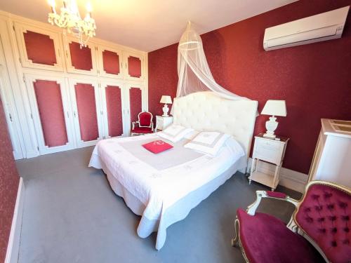 a bedroom with a white bed and red walls at Chateau de Quesmy in Quesmy