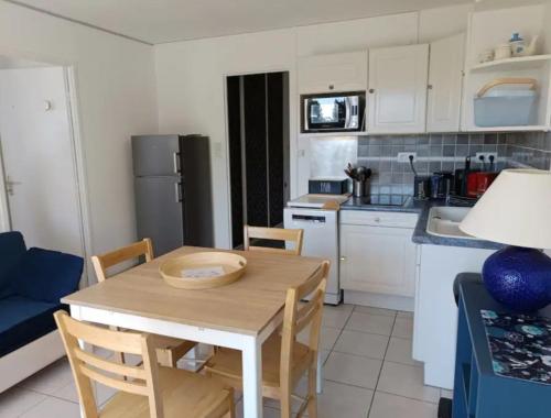 a small kitchen with a wooden table and chairs at T2 Parc du Golf in Pornic