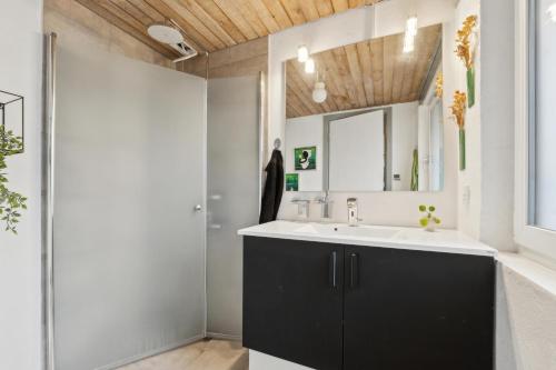 ein Badezimmer mit Waschbecken und Spiegel in der Unterkunft Feriehus 1102 in Ulfborg