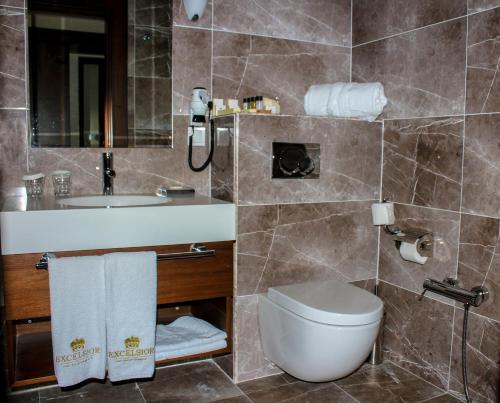 y baño con aseo y lavamanos. en Excelsior Hotel Shamkir, en Şǝmkir