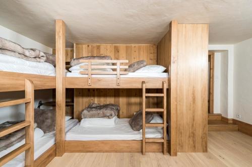 2 beliches num quarto com paredes de madeira em Joli Appartement familial Centre du village em Megève