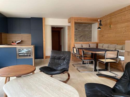 un salon avec une table et des chaises et une cuisine dans l'établissement Joli Appartement familial Centre du village, à Megève