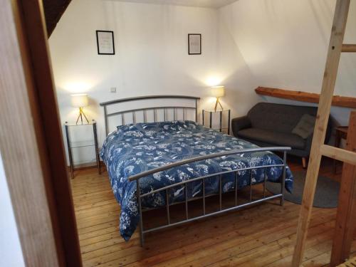 a bedroom with a bed and a couch at La Ferme de Frévan in Sarceaux