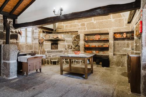 a stone room with a table and a fireplace at Cantinho da Tilde in Fafe