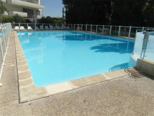 une grande piscine bleue avec des chaises dans un bâtiment dans l'établissement Appt Studio LA ROCHELLE - LR010-039, à La Rochelle