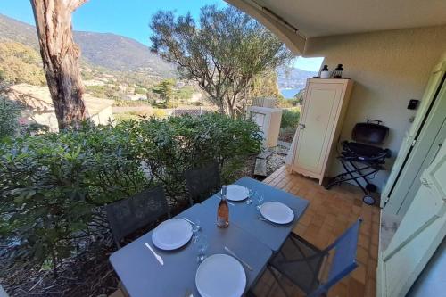 einen Tisch mit Tellern auf einer Terrasse in der Unterkunft F2 at "Domaine de la Pinède" Heated Swimming Pool in Le Lavandou