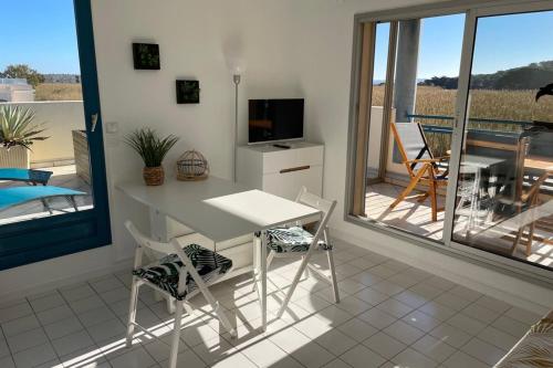 Il dispose d'un balcon et d'une cuisine avec une table et des chaises. dans l'établissement Domaine d'Azur - Renovated 1BR with Terrace Pool & Garage, au Lavandou