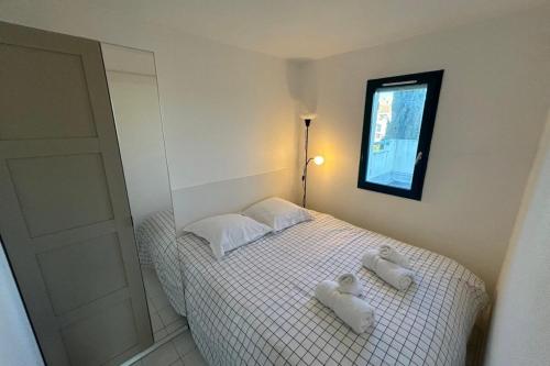 - une chambre avec 2 serviettes blanches sur un lit dans l'établissement Domaine d'Azur - Renovated 1BR with Terrace Pool & Garage, au Lavandou