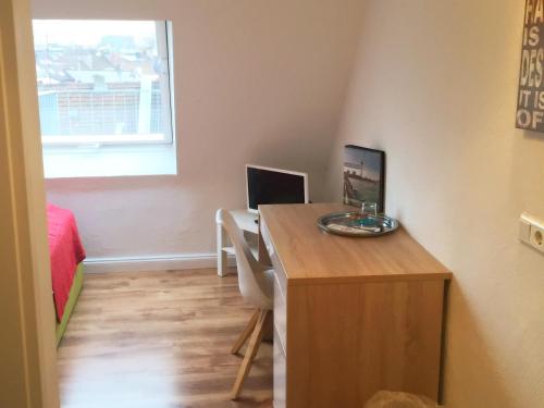 a small room with a desk with a computer on it at Studiotel Belle Etage in Düsseldorf